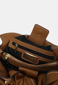 Borsa a mano in pelle marrone con finitura testurizzata, dotata di accessori dorati, interno in tessuto nero e numerosi scomparti con zip.