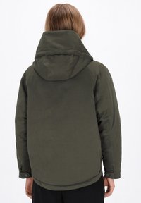 Olijfgroen, geïsoleerde jas met een grote capuchon, elastische manchetten en een iets langere achterkant. Materiaal lijkt glad met minimale details.