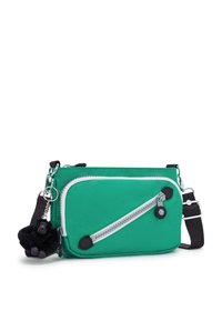 Grön nylon crossbody-väska med en diagonal dragkedjeficka, svarta accenter, silverfärgad hårdvara och en svart apa nyckelring.