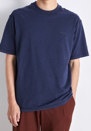 Marineblaues T-Shirt mit kurzen Ärmeln aus Baumwolle, mit Rundhalsausschnitt und dezentem Logodetail auf der Brust. Weiche Textur, lockere Passform.