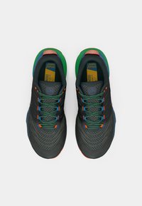 Fekete futócipők zöld kiegészítőkkel, mintás hálós felsőrész, többféle színű fűzők és narancssárga részlet a talpon, teljesítményre tervezve.