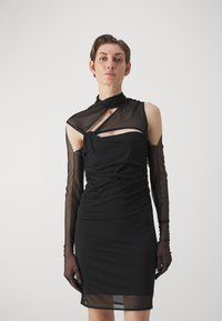 Rochie neagră cu mâneci lungi transparente, textură plisată, decolteu asimetric și un detaliu decupat pe piept. Material neted, siluetă ajustată.