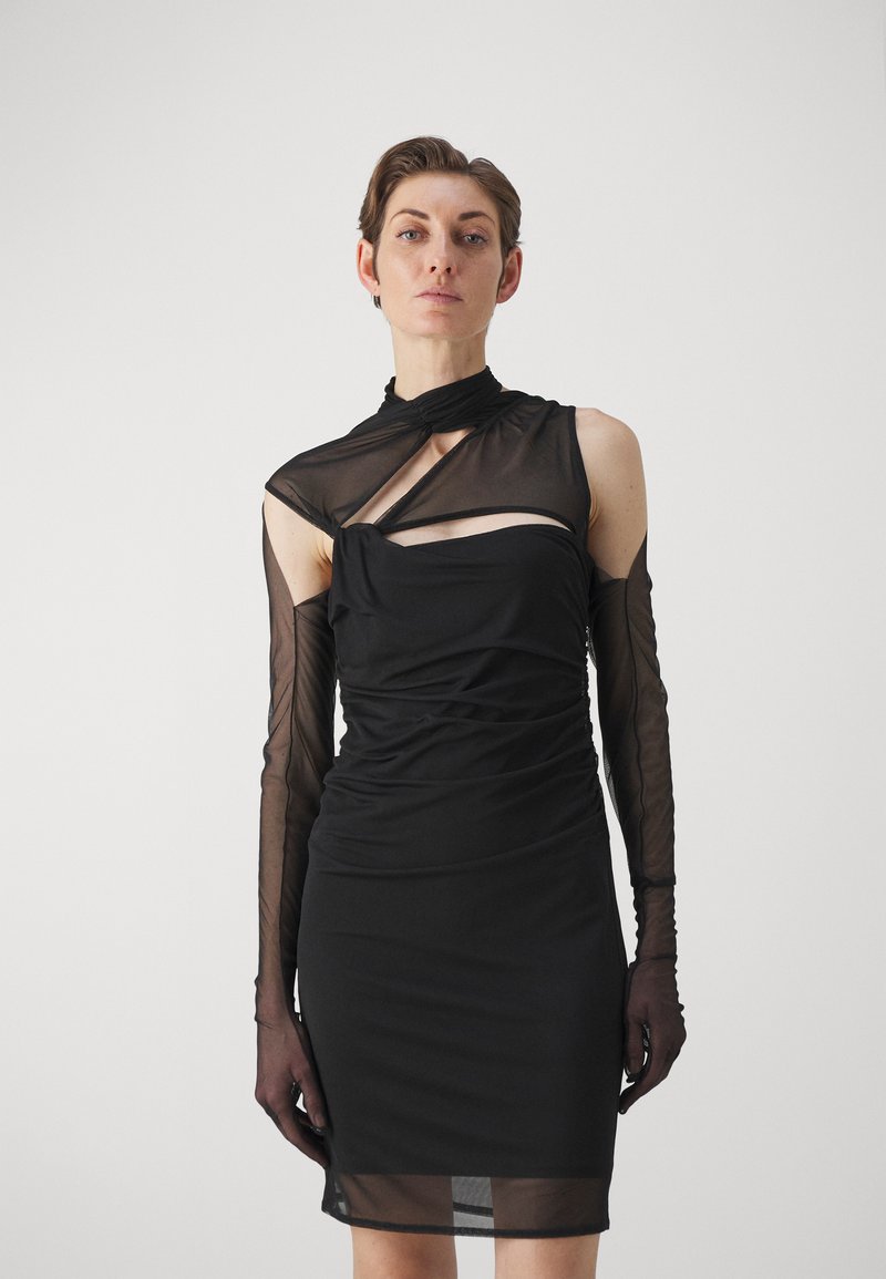 Rochie neagră cu mâneci lungi transparente, textură plisată, decolteu asimetric și un detaliu decupat pe piept. Material neted, siluetă ajustată.