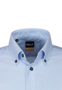 Camicia azzurra chiaro con un fit moderno. Presenta un colletto classico, dettagli in bottoni scuri e una texture intrecciata. Etichetta della taglia visibile.