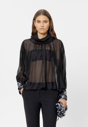 Black sheer blouse with a cowl neck, gathered at the shoulders, featuring textured sequined sleeves. Loose fit, elegant draping.