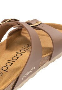 Sandalo in pelle marrone con soletta in sughero, dotato di due cinturini regolabili e una fibbia color oro. Soletta texturizzata, suola in gomma.