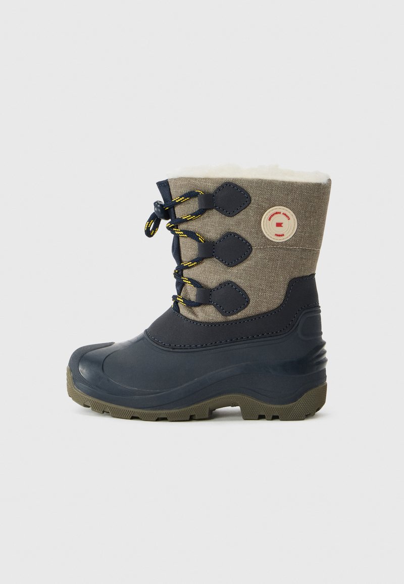 Bota de invierno con suela de goma oscura y parte superior de tela beige, con cordones negros acentuados en amarillo y forro de felpa blanca.
