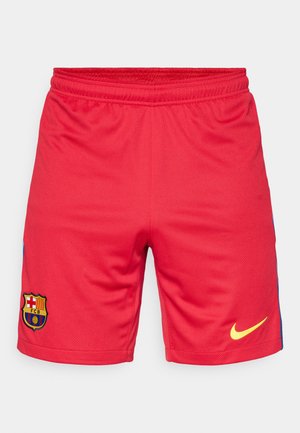 Raudoni sportiniai šortai, pagaminti iš kvėpuojančios medžiagos, su mėlynu šonu, geltonu Nike logotipu ir siuvinėtu FC Barcelona herbu.