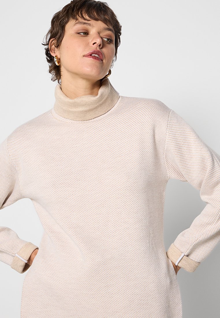 Beiges Strickkleid mit hohem Rollkragen und langen Ärmeln. Besitzt ein strukturiertes, gestreiftes Muster, kontrastierende Bündchen und einen lockeren Schnitt.