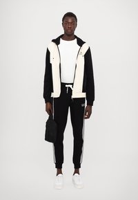 EA7 Emporio Armani PANTALONI - Treniņtērpa apakšdaļas - black