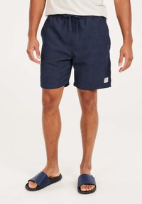 Marineblauwe shorts met een trekkoord in de taille, gemaakt van een gestructureerd materiaal; voorzien van zijzakken en een klein label op de zoom.
