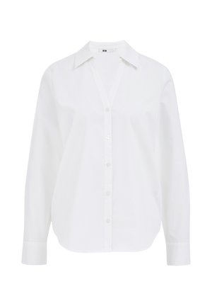 Bijela košulja dugih rukava od pamuka, s oštrim kragnom, opuštenog kroja i v-izrezom.