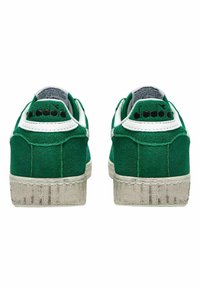 Sneaker in suede verde con dettagli bianchi. Suola in gomma spessa con motivo testurizzato. Logo in rilievo sul tallone e colletto imbottito per il comfort.