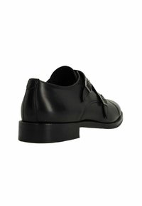 Zwarte leren schoen met een afgeronde neus, dubbele gespsluitingen en een lage, dikke hak. Glad van textuur en minimale stikseldetails.