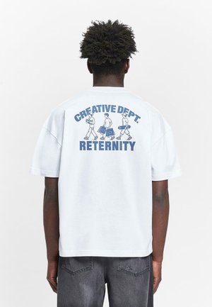 Tricou alb cu maneca scurta, avand o grafica albastra pe spate, care prezinta textul „CREATIVE DEPT.” deasupra ilustrațiilor a trei figuri și „RETERNITY” dedesubt.