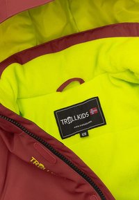 Maroon jacket interior with bright yellow fleece lining and an inner label reading “TROLLKIDS” with a Norwegian flag. Zipper closure.