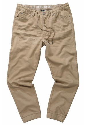 Pantaloni beige in tessuto elasticizzato con vita elastica, cordino e due tasche frontali. Presentano un design affusolato e caviglie cuffiate.