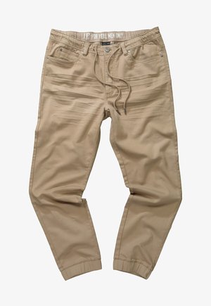 Beżowe spodnie z elastycznego materiału z gumką w talii, sznurkiem do regulacji oraz dwiema przednimi kieszeniami. Posiadają zwężany krój i mankiety u kostek.