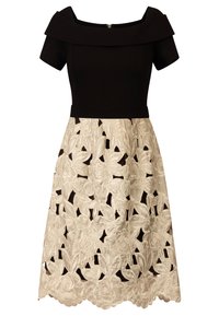 Vestito nero off-shoulder con top aderente e maniche corte; gonna a campana color crema con ricami floreali e motivi a intaglio.