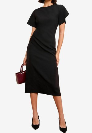 Czarna sukienka midi z krótkimi, falbaniastymi rękawami, dopasowanym krojem i gładką fakturą. Połączona z bordową torebką i czarnymi, szpiczastymi szpilkami.