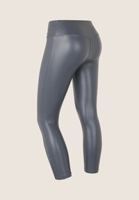 Leggings de talle alto en gris, confeccionados con un material liso y elástico con detalles de costuras, ajustados en los tobillos para un look ceñido.
