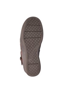 Bruine suède instapschoen met een geprofileerde rubberen zool voorzien van een cirkelvormig loopvlakpatroon en de merknaam "SKECHERS" in relief aan de zijkant.
