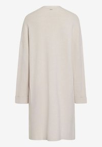 Długi, luźny strój w jasnobeżowym kolorze z okrągłym dekoltem i rękawami o długości trzech czwartych, z podwiniętymi mankietami i gładką, miękką teksturą.