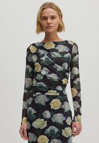 Langärmliges Oberteil aus transparentem schwarzem Stoff mit einem Blumenmuster aus gelben und weißen Rosen sowie gerafften Details an den Seiten.