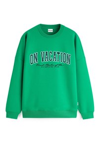 Sweatshirt vert à col rond avec l'inscription "EN VACANCES" en grandes lettres blanches et contour noir, avec un texte plus petit en dessous indiquant "Membre fier du club du rien faire."