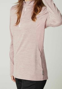 Lyserød langærmet pullover med lynlås i halsen, lavet af struktureret stof med kontrasterende sømdetaljer, ideel til træningstøj.