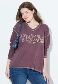 Maglietta bordeaux a maniche lunghe con scollatura a V, con la scritta "TEXAS est. 1987" stampata in beige, caratterizzata da un taglio rilassato e dettagli di cucitura a contrasto.