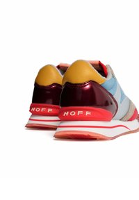 Zapatillas multicolores con detalles de cuero amarillo, un tacón brillante en color burdeos y una suela blanca con franjas rojas. Logo "HOFF" en el talón.