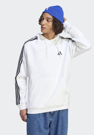 Sudadera blanca con diseño de tres rayas negras en las mangas, capucha con cordones y bolsillo canguro frontal. Tejido suave, corte informal y branding minimalista.