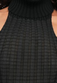 Černý žebrovaný pletený top s vysokým výstřihem a odhalenými rameny, s texturovaným mřížkovým vzorem a přiléhavým střihem.