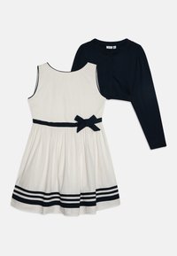 Vestido blanco con rayas marinas y un lazo en la cintura, combinado con un cárdigan corto azul marino. Material de algodón, cuello redondo, diseño sin mangas.