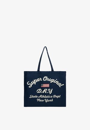 Marineblauwe draagtas met twee handvatten, met witte tekst "Super Original D.R.Y State Athletics Dept New York" en een kleine afbeelding van de Amerikaanse vlag.