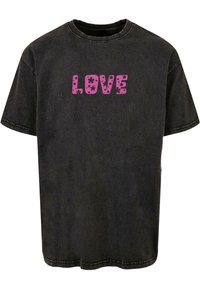Zwart katoenen T-shirt met een relaxte pasvorm, ronde hals en een roze grafisch ontwerp met bloemaccenten dat "LOVE" op de voorkant spelt.