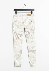 Vita byxorna med blommönster i pastellfärger och grön växtlighet. Har två bakfickor med dragkedja och en texturerad midjebandsetikett.