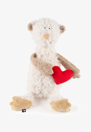 Fluffy white teddy bear with beige arms and feet holding a red heart-shaped plush toy against a white background.