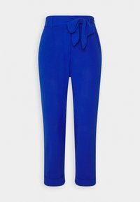 Pantalon bleu vif fuselé avec ceinture en tissu nouée à la taille et ourlets retroussés sur un fond uni.