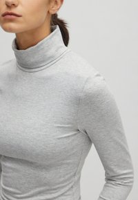 Grijze turtleneck top met lange mouwen, gemaakt van zachte, rekbare stof. Heeft een getailleerd ontwerp en minimale naaddetails.