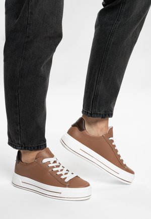 Brown leather sneakers with white laces and rubber soles, featuring a contrasting brown heel accent and horizontal stripe detail.