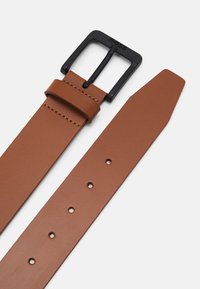 Brauner Leder Gürtel mit einer schwarzen rechteckigen Schnalle, der eine glatte Textur, Stichdetails und mehrere Perforationen entlang des Riemens aufweist.