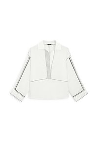 Chemise blanche à col, présentant des détails de couture noire le long des manches et de la patte de boutonnage, avec une coupe décontractée.