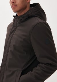 Dark brown padded jacket with a hood, featuring a zip closure, side pockets, and a textured patch on the left sleeve. Smooth fabric finish.