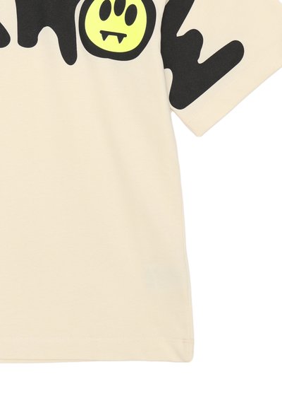 T-shirt in cotone beige con un grande motivo grafico nero che presenta un volto sorridente giallo con zanne, maniche corte e collo a giro.