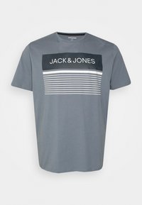 Camiseta de algodón gris con un estampado gráfico que incluye "JACK&JONES" y rayas horizontales en blanco y azul marino. Corte de mangas cortas, escote redondo.