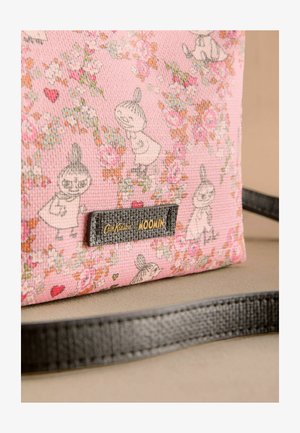 Rozā auduma soma ar Mūmiņu varoņiem, ziedu rakstiem un melnu ādas etiķeti ar uzrakstu "Cath Kidston Moomin", izspiests. Plakana siksna.