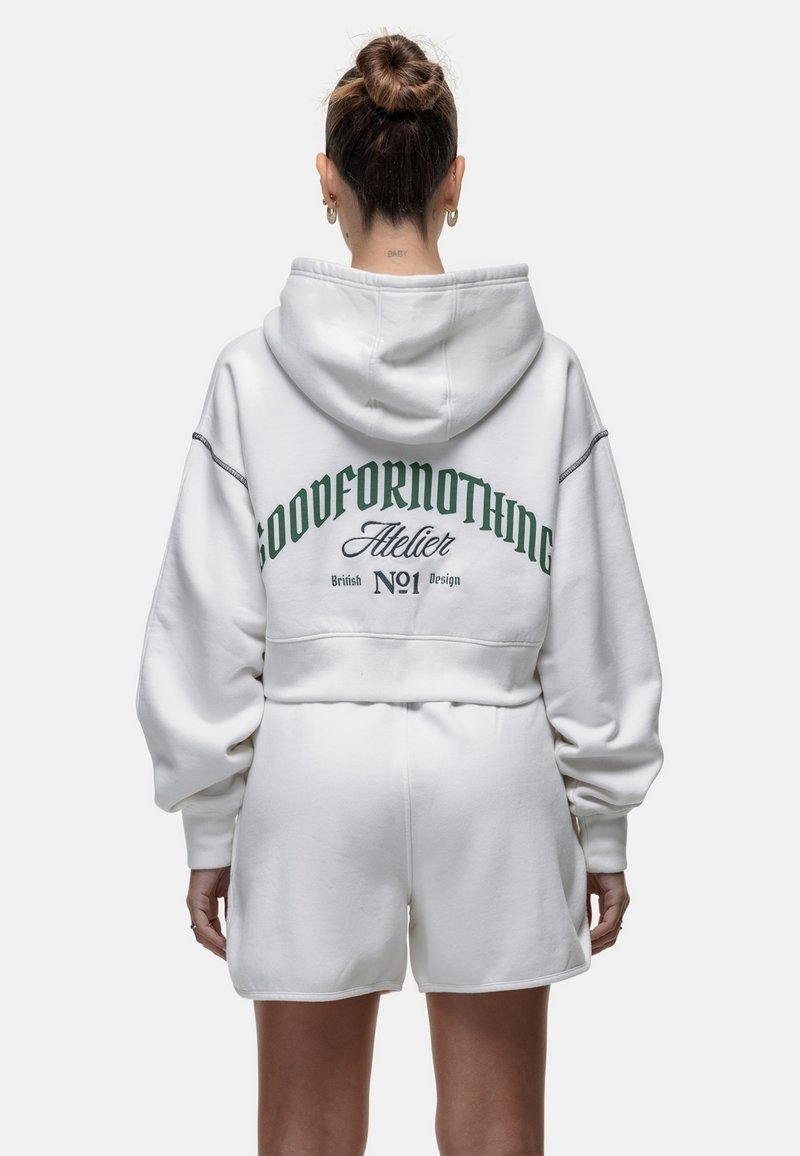 Witte cropped hoodie met groene tekst "GOODFORNOTHING" en branding op de achterkant. Heeft een pull-over capuchon en oversized mouwen.