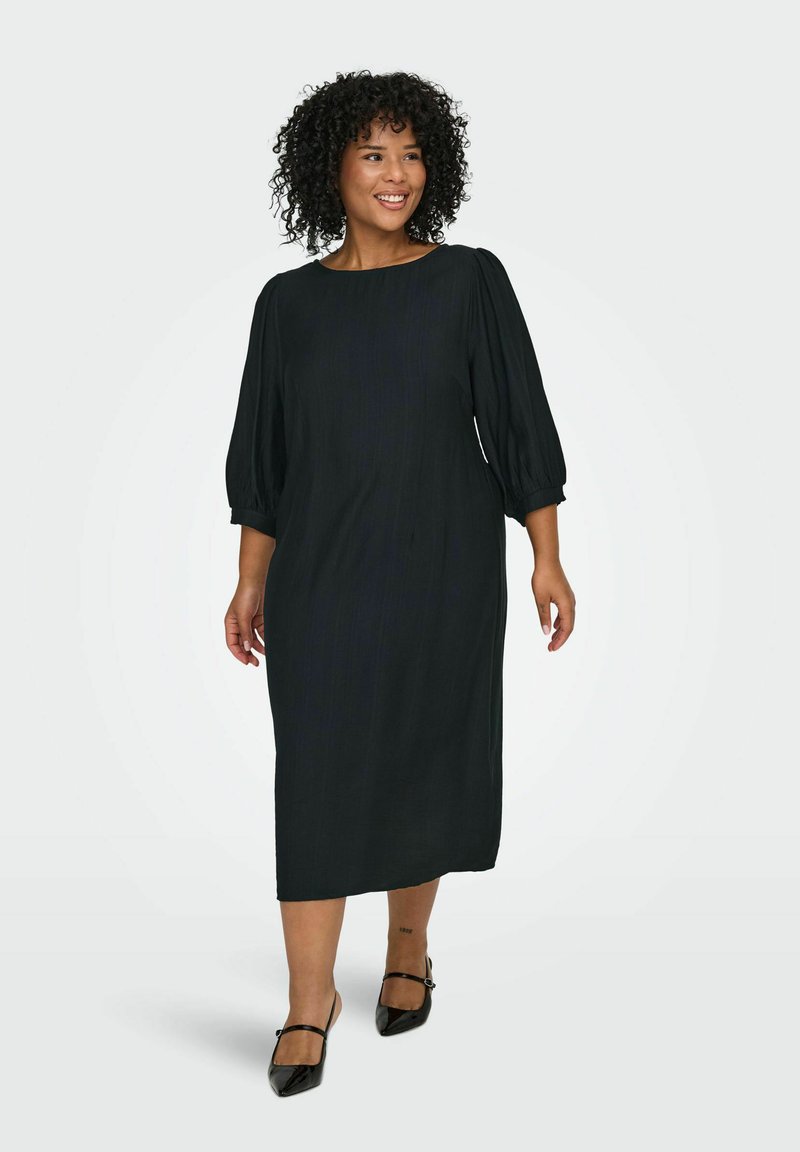 Melna kleita līdz ceļiem ar trīs ceturtdaļu puff piedurknēm un apaļu dekoltē, izgatavota no gludas, strukturētas auduma. Izstrādāta ar minimālisma dizainu.